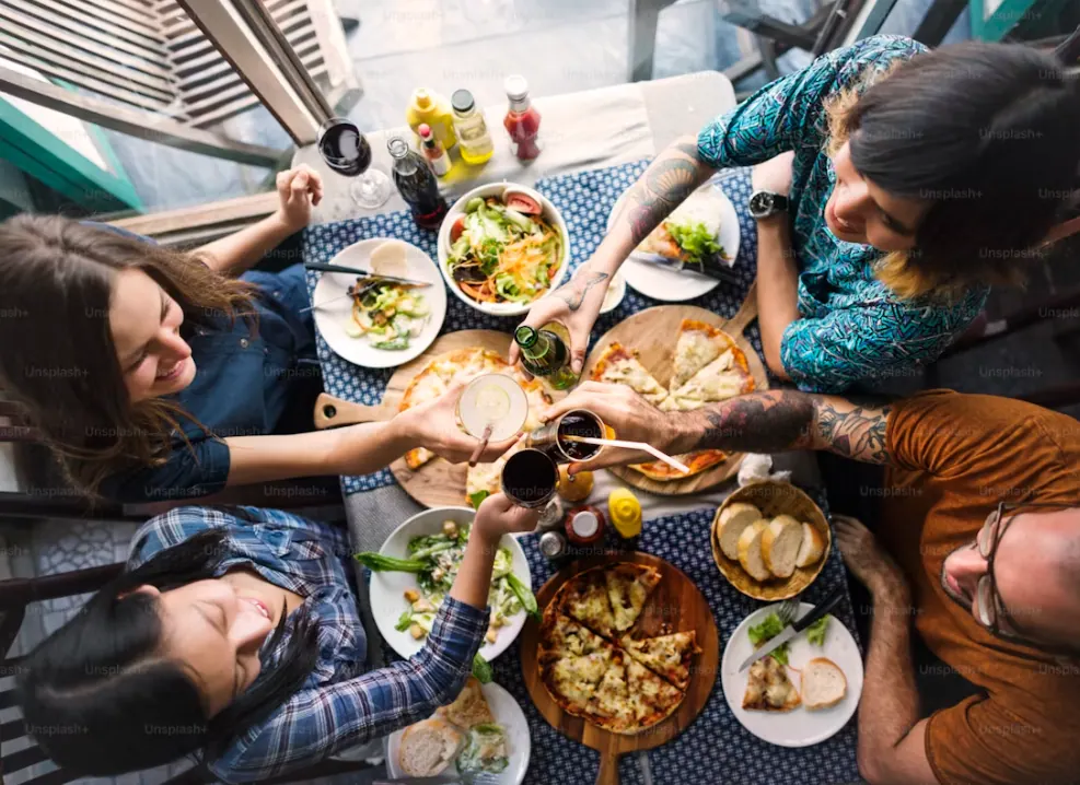 Grupo de amigos compartiendo pizza en una mesa informal